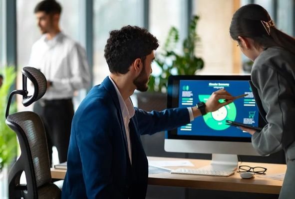 Equipo de trabajo revisa un gráfico en un computador de escritorio