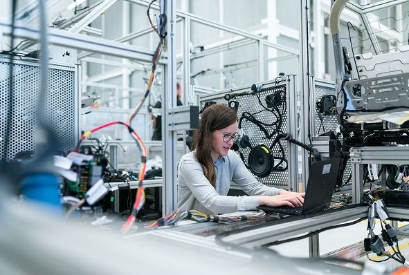 Investigadora trabaja con un notebook en un laboratorio de robótica